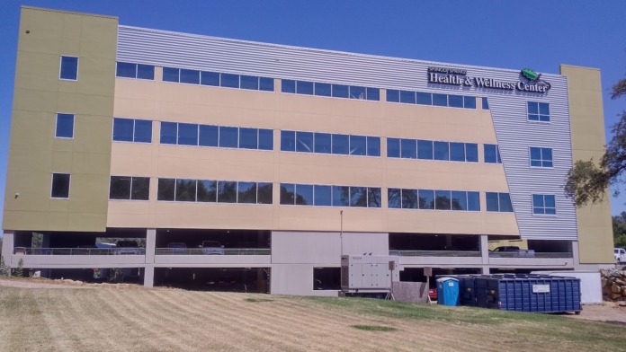 Exterior of multi-story treatment facility with tan and peach colored panels, multiple windows, and modern architectural design