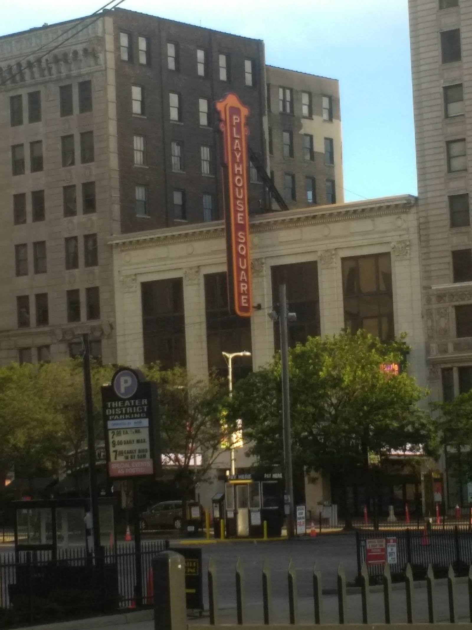 Exterior view of urban street with multiple brick buildings, vehicles, and nearby Payhouse Square signage