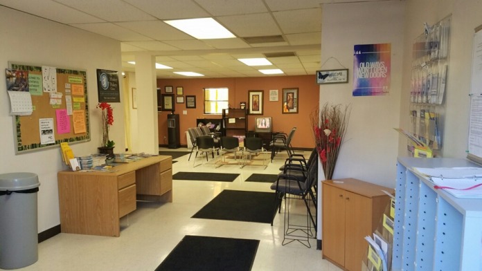 Interior office area with desks, filing cabinets, motivational signage, and administrative work stations