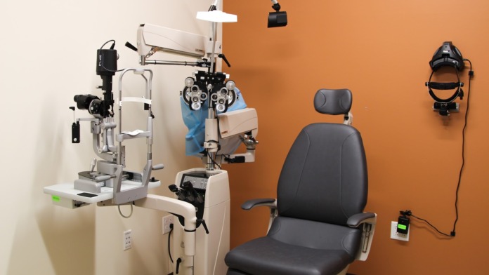 Interior vision testing facility with phoropter equipment, specialized diagnostic instrumentation, and examination chair
