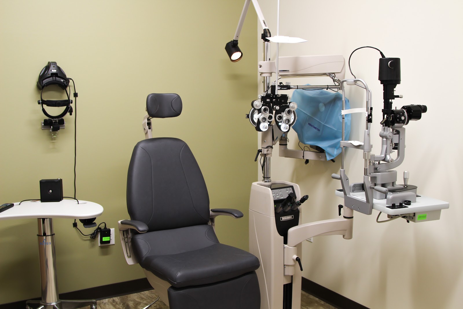 Interior optometry exam room with phoropter equipment, patient chair, and diagnostic instrumentation