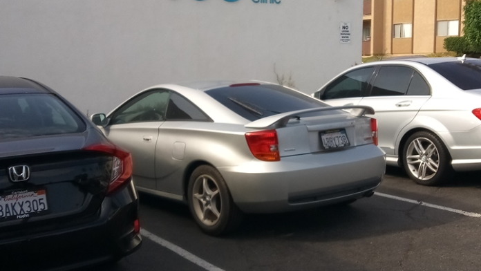 Exterior view of white building with Vista Community Clinic logo on wall and parked vehicles in lot