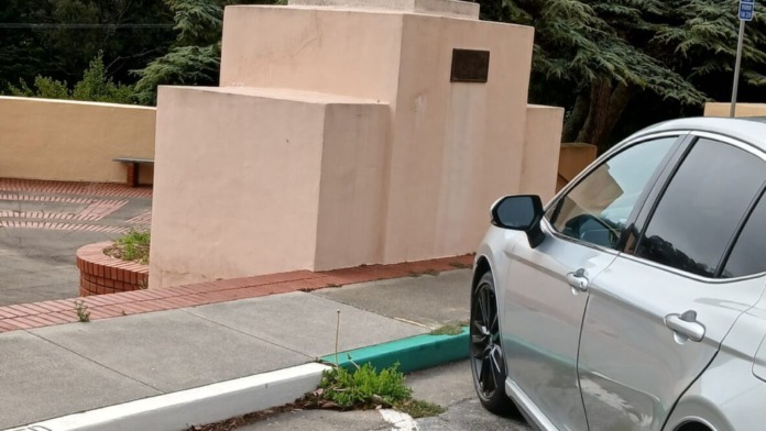 Exterior parking area with visitor spaces and commemorative statue on facility grounds
