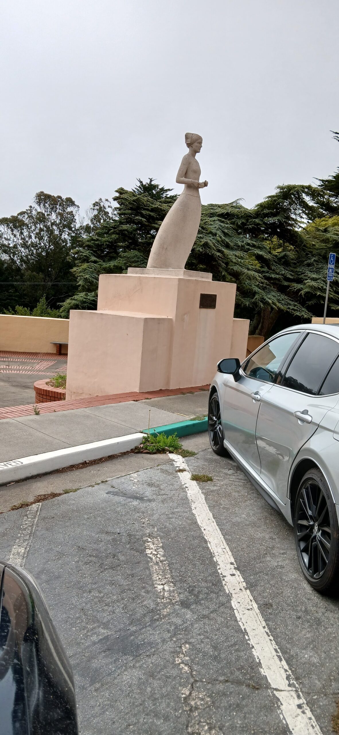 Exterior parking area with visitor spaces and commemorative statue on facility grounds