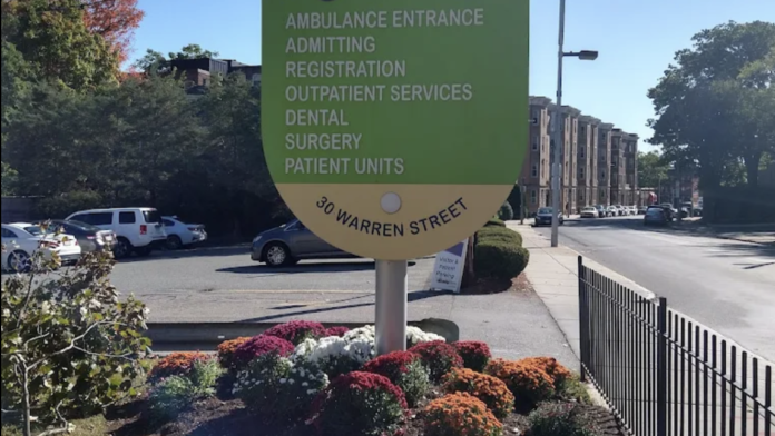 Exterior showing large Franciscan Children's directional sign with parking area, landscaping, and street view