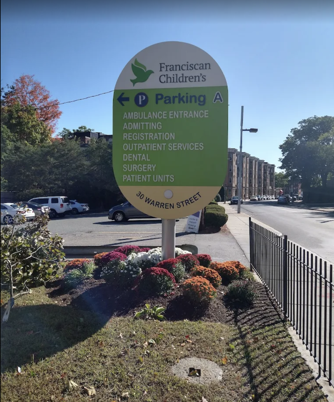 Exterior showing large Franciscan Children's directional sign with parking area, landscaping, and street view