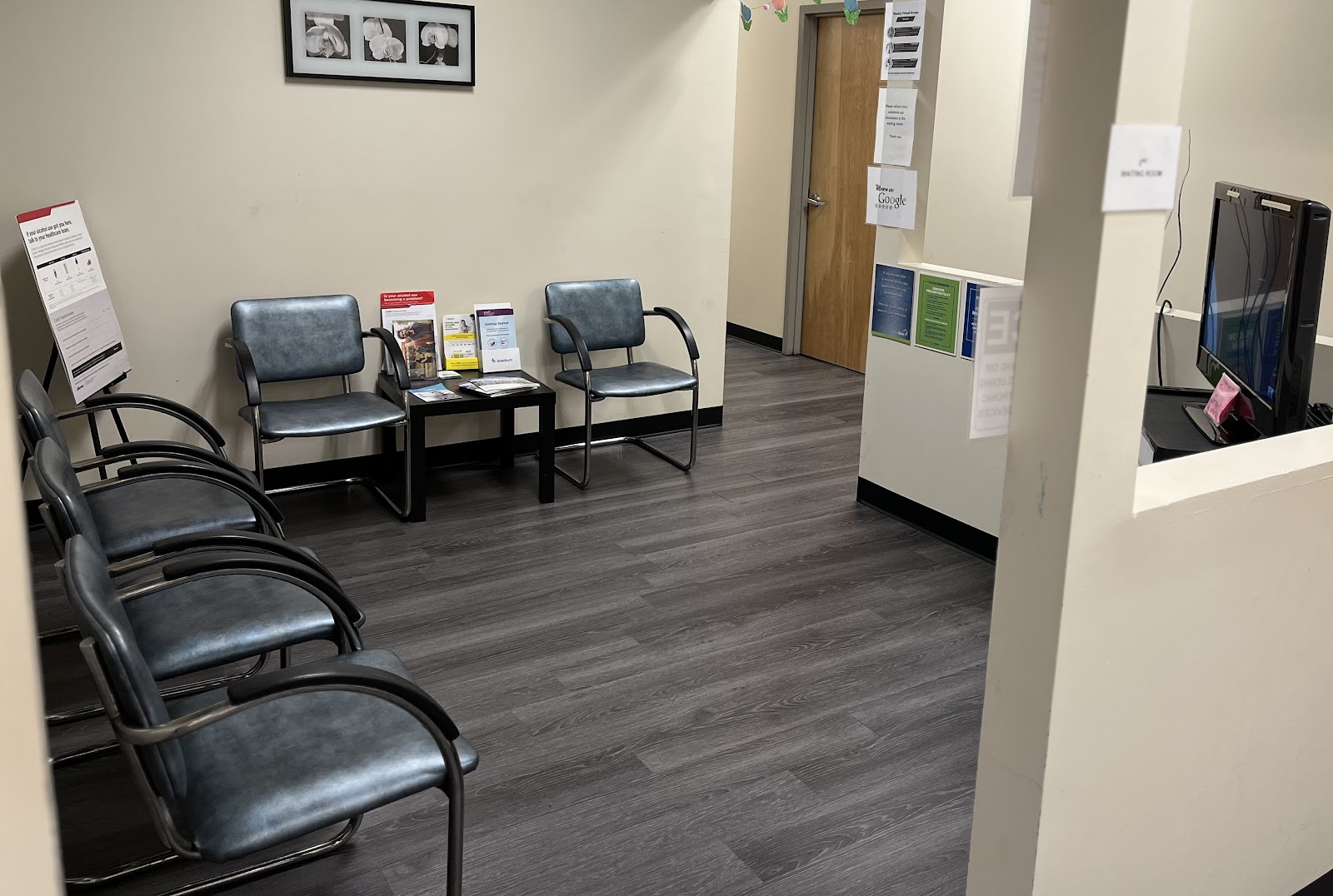 Interior reception area with waiting chairs, check-in counter, and educational materials displayed on walls