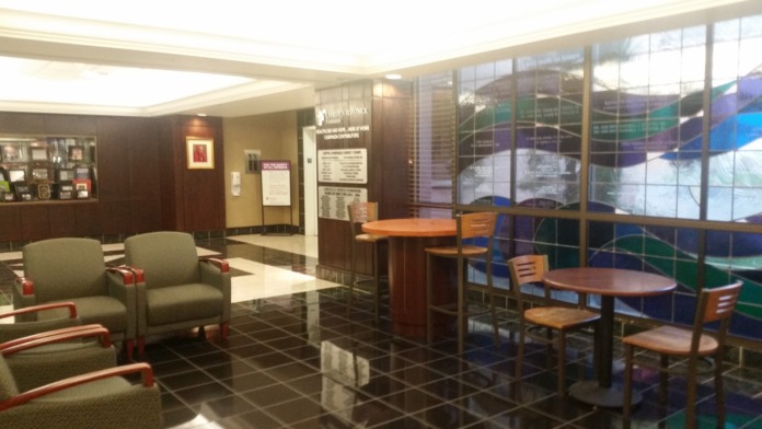 Interior lounge with comfortable seating, round tables, windows, and modern furnishings for visitors and patients