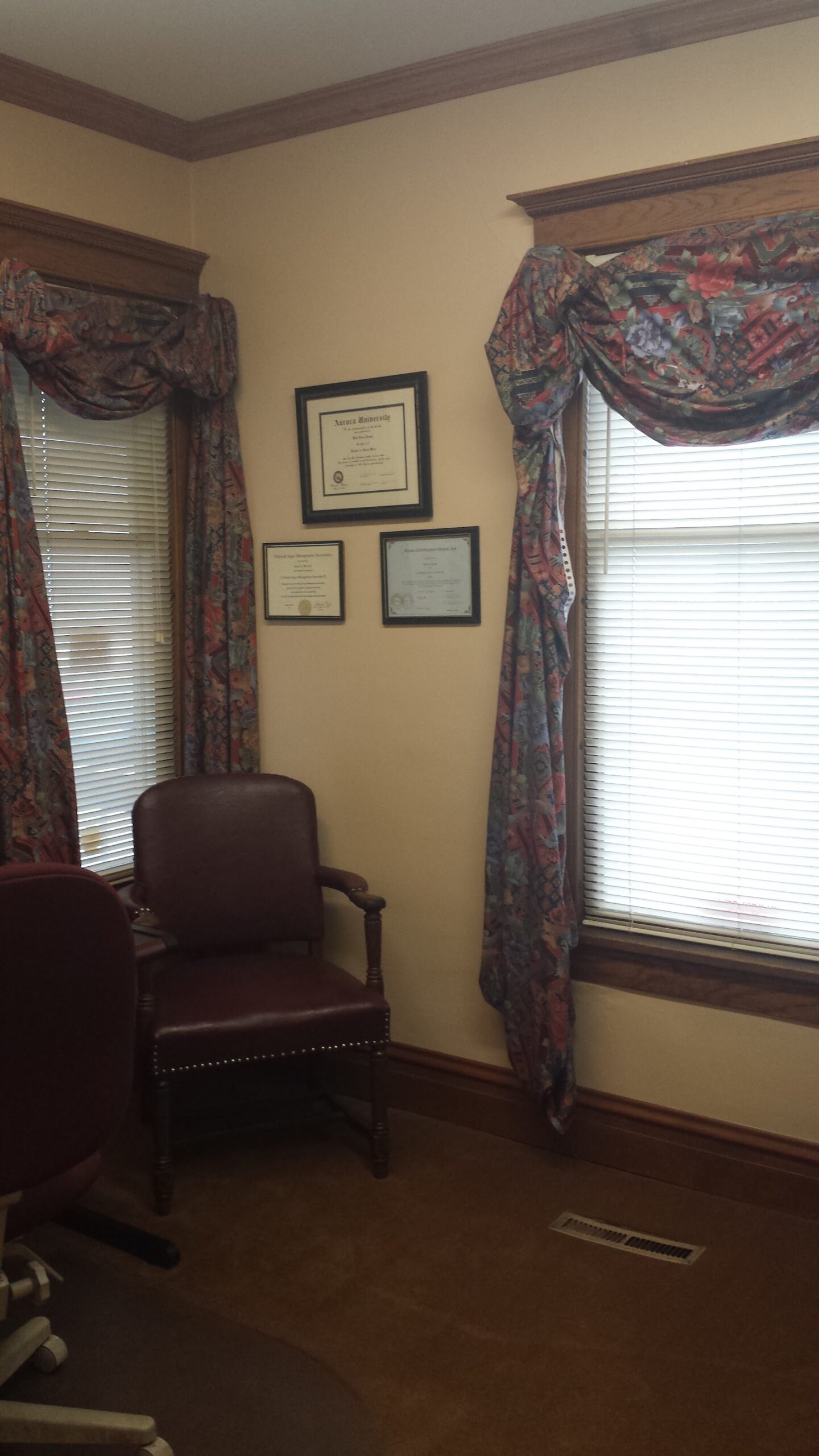 Interior private office with professional furnishings and framed certifications on walls