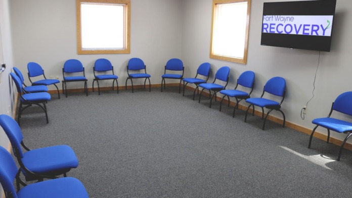 Interior reception area with wooden framed window and Fort Wayne Recovery facility signage