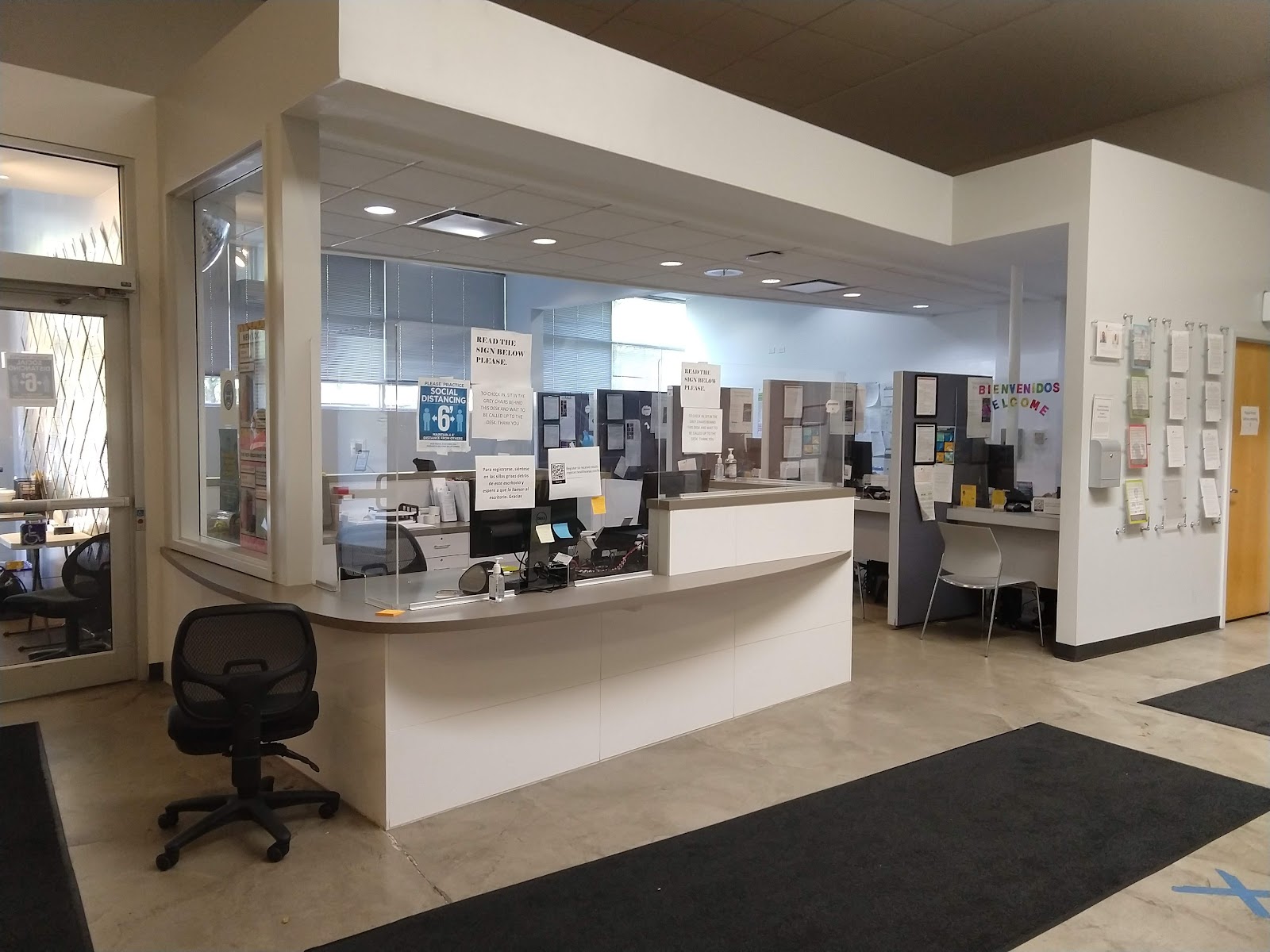 Interior reception counter with staff workspace, glass partitions, and patient check-in desk area