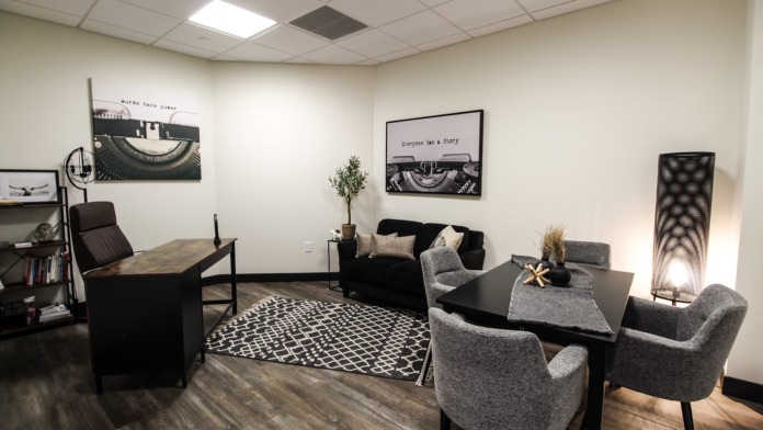 Interior common area with contemporary furnishings, framed artwork, patterned rug, and decorative lighting fixtures.