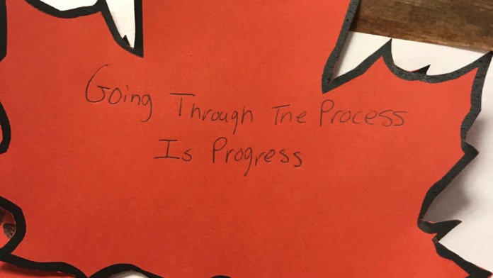 Close-up of handwritten motivational leaf craft display with empowering message about recovery process.