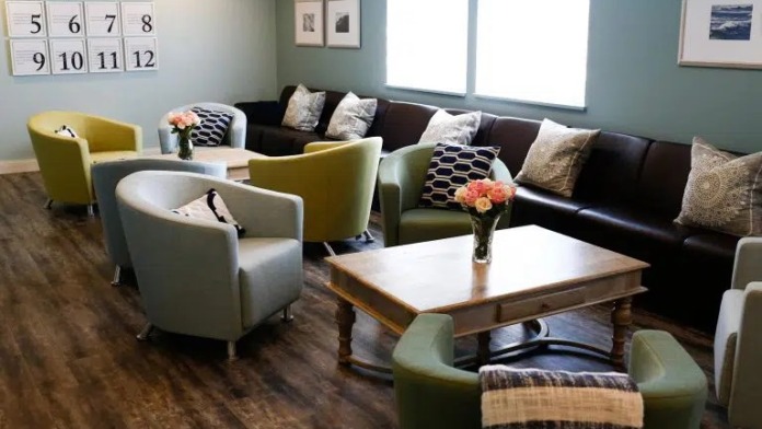 Interior common area with comfortable seating, calendar wall display, and contemporary furnishings for patient gatherings