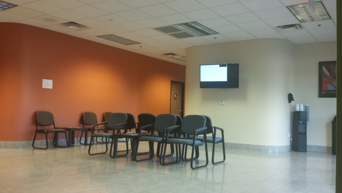 Interior recreation area with magazines on table, lounge seating, and television mounted on wall