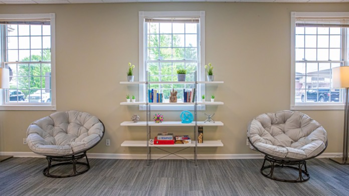 Interior recreation room with shelving displays, decorative items, and recreational equipment for patient activities