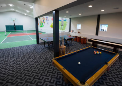 Interior entertainment space with billiards table, ping pong table, and game room amenities for resident activities