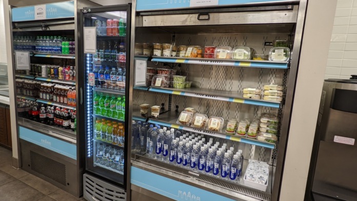 Interior refrigerated display cases and beverage coolers with various drinks, snacks, and food items available