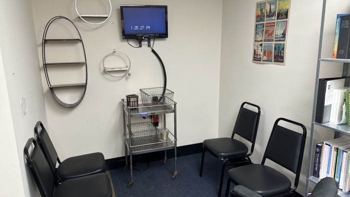 Interior room with decorative table display featuring meditation figure, recovery-focused books, and promotional materials