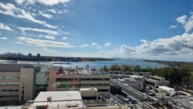 Exterior aerial view showing facility rooftop, surrounding buildings, river views, and bridge in background