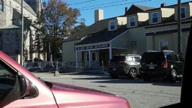 Exterior view of SCADD Detox Entrance facility showing entrance signage, parking area with vehicles, and surrounding street.