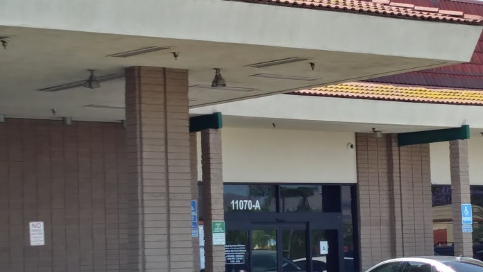 Exterior view of unit 11070-A entrance with covered canopy, brick facade, and accessible parking signage