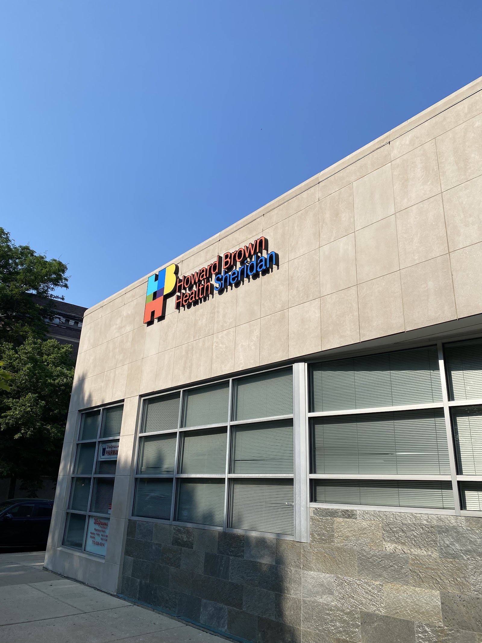 Exterior view of treatment center entrance door displaying Howard Brown Health Sheridan location signage and operating hours