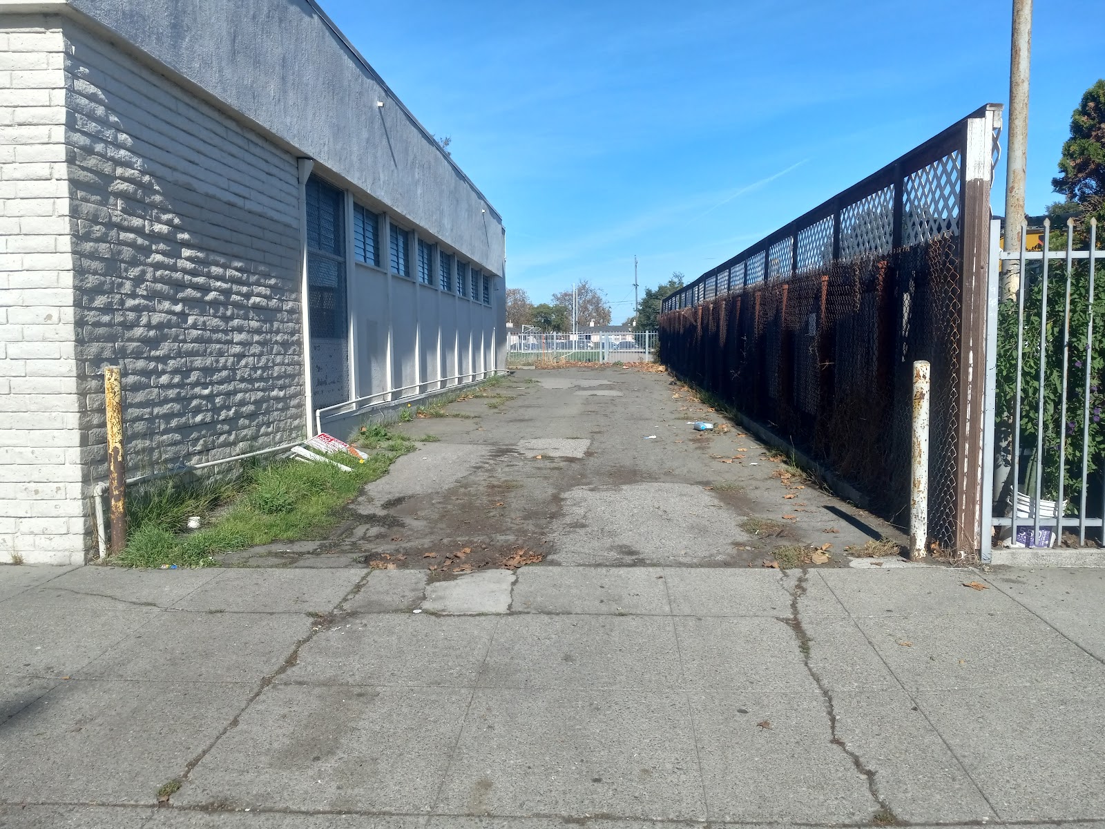 Exterior view showing facility side building, fenced courtyard area, and perimeter security fencing