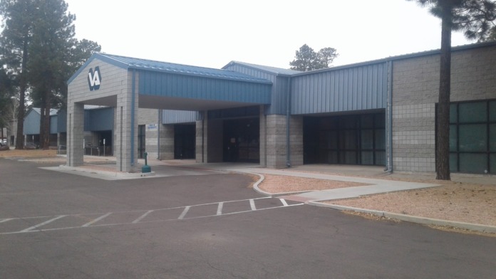 Side view of VA facility showing entrance with covered portico, stone construction, and parking access