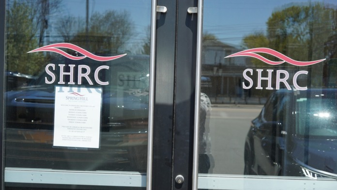 Exterior building entrance showing brick facade, SHRC logo on window, and street address number 604