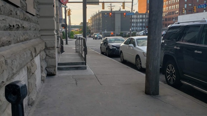 Exterior street view showing facility entrance area with sidewalk, building facade, and urban street