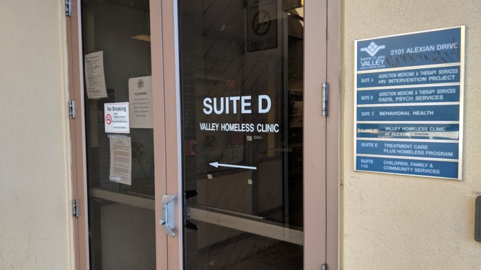 Entrance door and directional signage for Valley Homeless Clinic and Addiction Medicine Therapy Services.