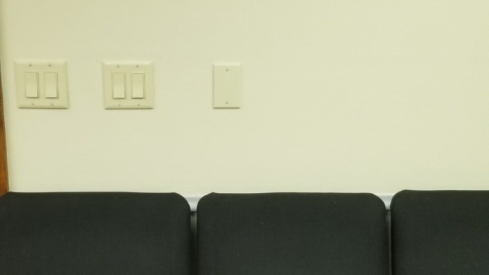 Interior waiting room with seating and framed motivational posters about ability and strength