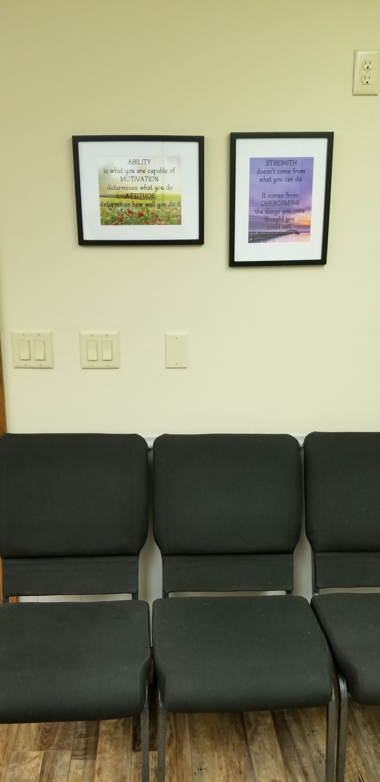 Interior waiting room with seating and framed motivational posters about ability and strength