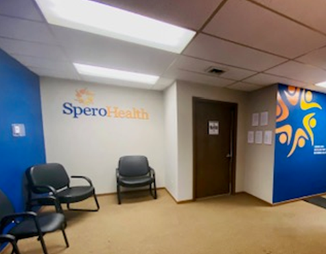 Interior waiting room with blue walls, Spero Health signage, seating chairs, and treatment facility entrance door
