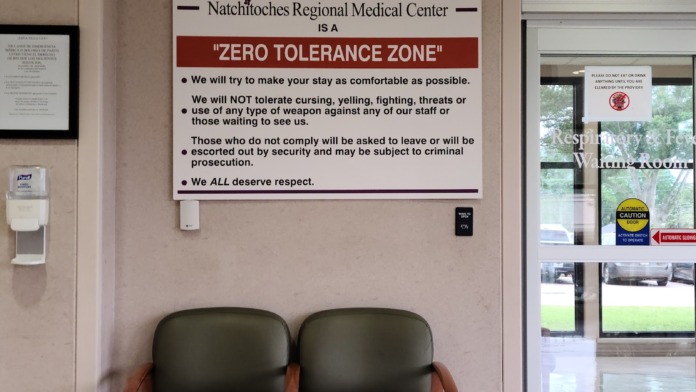 Interior lobby seating area with waiting chairs and Zero Tolerance Zone signage policy displayed on wall