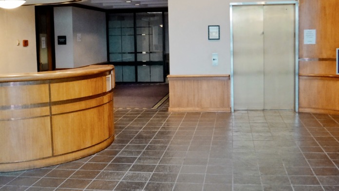 Interior waiting room with multiple chairs arranged for patients, framed artwork, and office doors