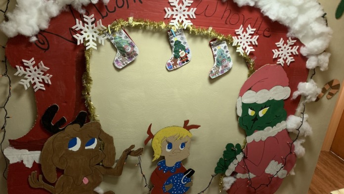 Interior wall decoration with festive holiday ornaments, lights, stockings, and seasonal artwork