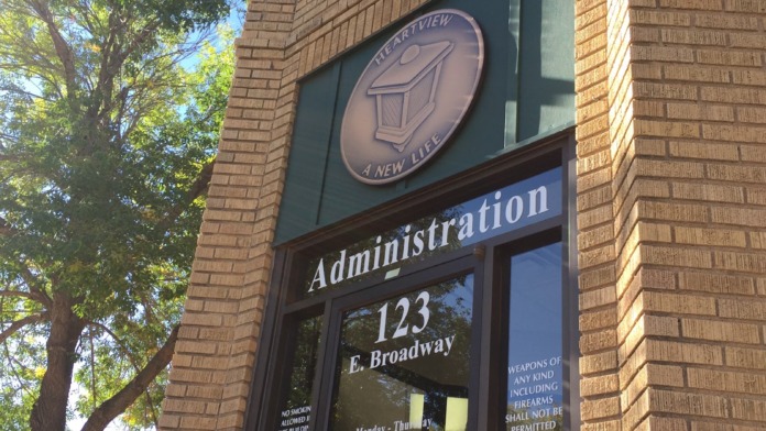 Exterior brick building corner showing Heartview Foundation administrative entrance with signage, hours, and facility address