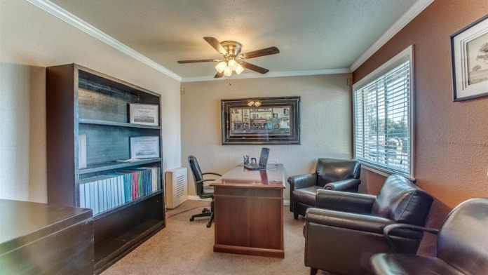 Interior office area with desk, leather seating, bookshelf, and artwork on walls for client consultations