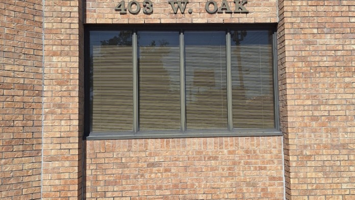 Brick facade showing street address 403 W. Oak with horizontal window banding.