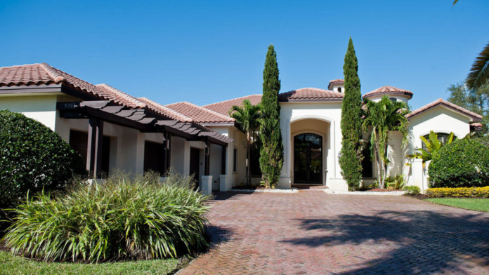 Front exterior entrance showing address 1690, white stucco facade, glass entry doors, covered portico, and landscaped plant beds