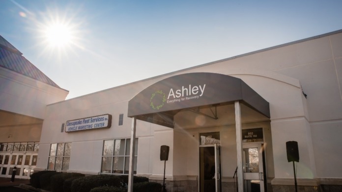 Exterior view of treatment facility entrance with tan building facade, Ashley branding, entrance doors, and landscaping