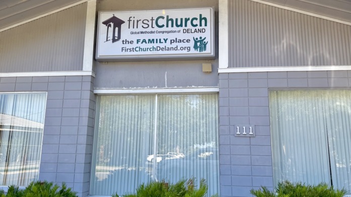 Exterior view of building with signage displaying facility information and address numbers on tiled facade