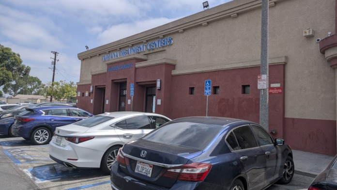 Exterior facade of treatment facility with maroon and tan colored walls and main entrance doors