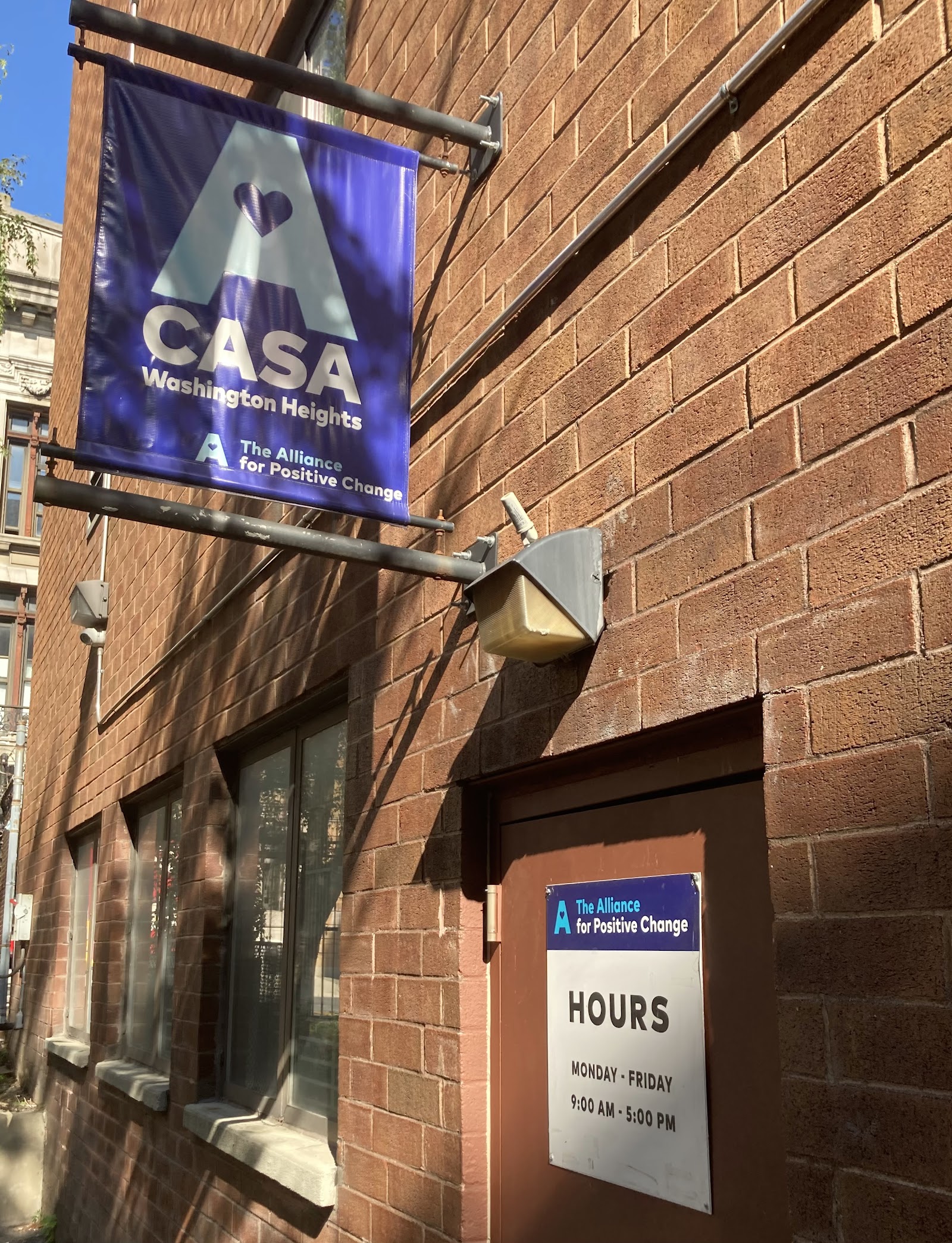 Exterior brick facade displaying CASA Washington signage and facility operating hours information.