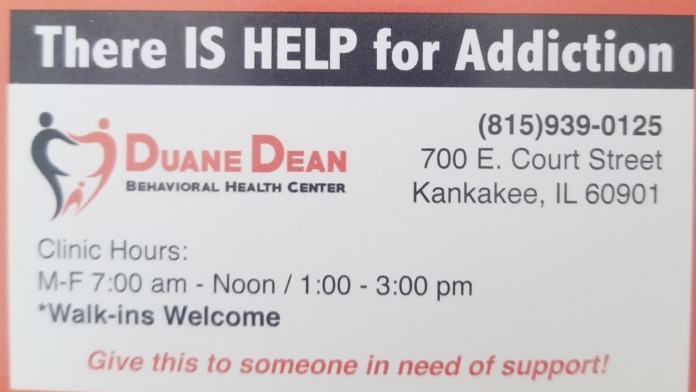 Interior view showing addiction treatment flyer with facility branding, clinic hours, address, and contact information