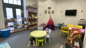 Interior playroom with colorful furniture, storage cubbies, tent structure, and educational materials for children's activities