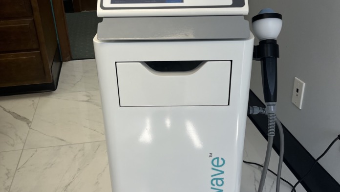 Interior clinical space showing Stemwave medical device on marble flooring with doorways and medical supplies visible.