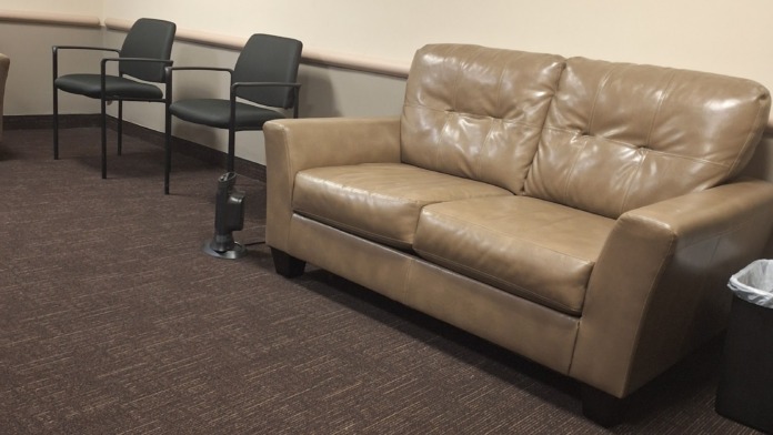 Interior common space with AppleGate Recovery acrylic signage, leather seating, and brown carpet.